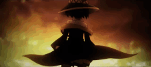 a silhouette of a person wearing a hat standing in front of a fire