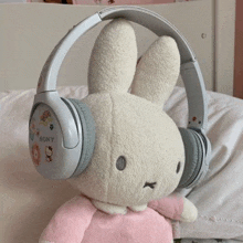 a stuffed bunny is wearing headphones on top of a bed .