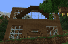 a minecraft house with a lot of windows and a few trees in the background