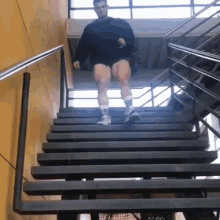 a man walking up a set of stairs wearing nike shorts and socks