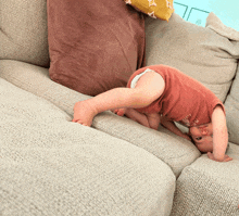 a baby is doing a handstand on a couch wearing a shirt that says i love you