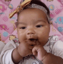 a baby girl wearing a headband and a hello kitty shirt