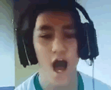 a close up of a person wearing headphones and singing .