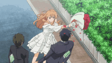 a girl in a white dress is throwing a bouquet of roses at a man