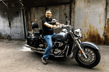 a man sitting on a motorcycle wearing a black shirt that says u.n.c.t.