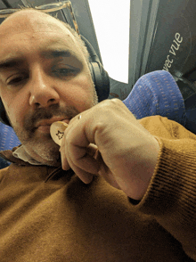 a man wearing headphones and a brown sweater is holding a key with a star on it