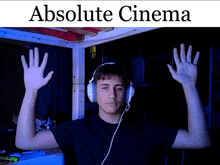 a man wearing headphones and a black shirt with the words absolute cinema above him