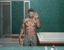 a shirtless man with tattoos on his arms and chest is standing in front of a bathroom mirror