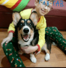 a boy in a yellow shirt is kneeling down with a dog and the words fab-fab are visible in blue