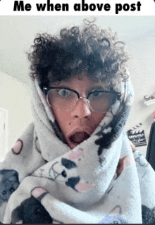 a man with curly hair is wrapped in a blanket with a panda on it .