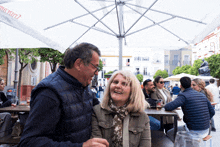 a man and woman sit under an umbrella that says " estrella "