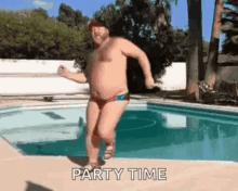 a shirtless man in a red swim trunks is dancing in a pool .