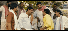 a group of men are standing around a tree talking