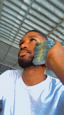 a man in a white shirt is holding a stack of money