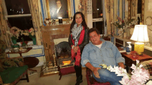 a man and a woman pose in front of a fireplace