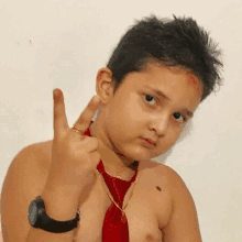 a shirtless young boy wearing a red tie and a black watch shows the middle finger