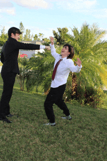 a man in a suit is holding another man in a tie