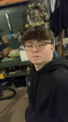 a young boy wearing glasses and a black hoodie