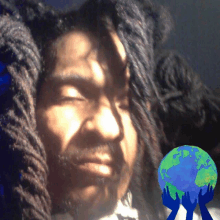 a man with dreadlocks has his eyes closed and a globe in his hands