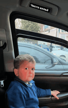 a young boy sits in the back seat of a car with a sticker on the roof that says чисто аллье