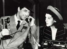 a man in a suit is talking on a telephone next to a woman