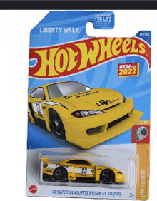 a yellow hot wheels car is on a card