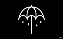 a white umbrella with rain drops on it on a black background .