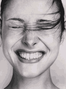 a close up of a woman making a funny face with her eyes closed .