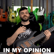 a man holding a guitar in front of a wall of guitars with the words in my opinion above him