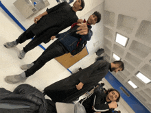 a group of young men are posing for a picture in a room with a ceiling that has squares on it