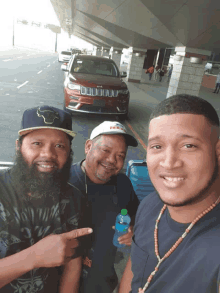 three men posing for a picture in front of a jeep