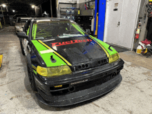 a green and black car with fueltech written on the hood