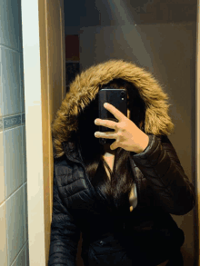 a woman taking a picture of herself in the mirror