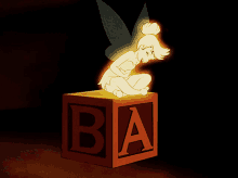 a fairy is sitting on a block with the letter b on it