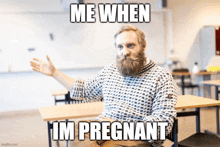 a man with a beard and mustache is sitting in a classroom with a meme that says me when im pregnant