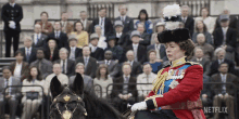 a woman in a military uniform is riding a horse in front of a crowd with netflix on the bottom right