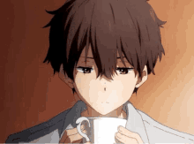 a boy is drinking a cup of coffee from a white cup