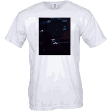 a white t-shirt with a picture of a man playing a piano