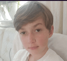 a young boy is sitting on a white couch