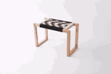 a small wooden stool with a black and white pattern on it