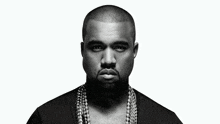 a black and white photo of kanye west wearing a black shirt and chains around his neck