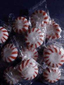 a pile of red and white peppermint candies in plastic wrappers