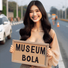 a woman holding a sign that says museum bola on it