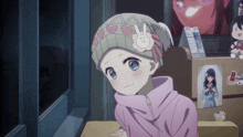 a girl wearing a pink hoodie and a grey hat with a bunny on it