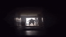 a silhouette of a man standing in a dark hallway