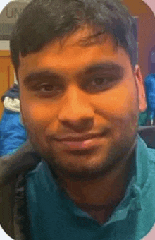 a close up of a man 's face with a beard wearing a blue shirt .