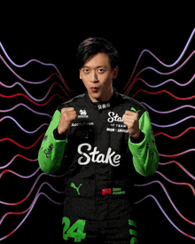 a man in a black and green racing suit with the word stake on it