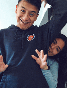 a man and woman are posing for a picture and the man is wearing a hoodie that says " i love you " on the front