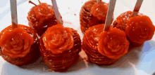 a white plate topped with red candy apples with roses on them