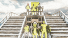 a group of people standing in front of a staircase with a sign that says " a few steps to heaven "